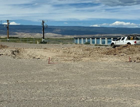 Stakes and string lines marking out the concrete slabs for the new exterior lumber racks