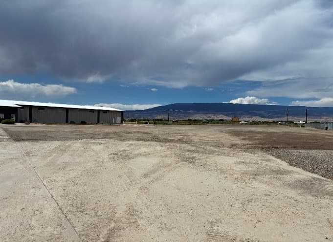 The newly graded site at 1755 Gunnison Ave, with our existing building and the Grand Mesa in the background
