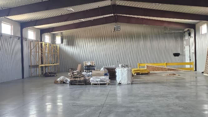 The open lumber warehouse with racking in place and the first pallets of stock arriving